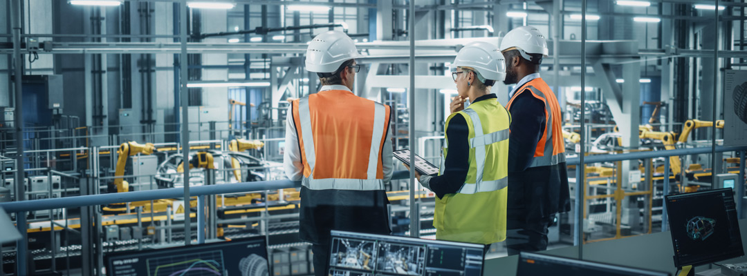 Young Diverse Team of Automotive Engineers Working in Office at Car Factory
